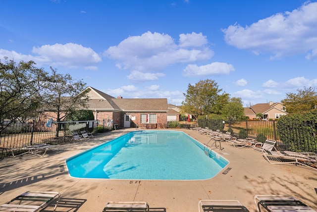 community pool with a patio and fence