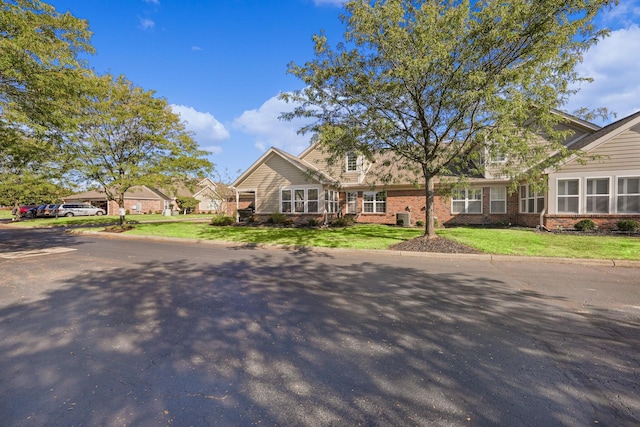 view of front of home featuring brick siding and a front yard