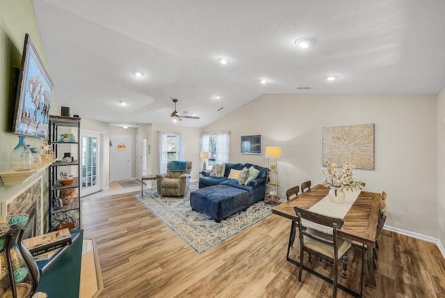 living room with baseboards, light wood-style floors, and vaulted ceiling