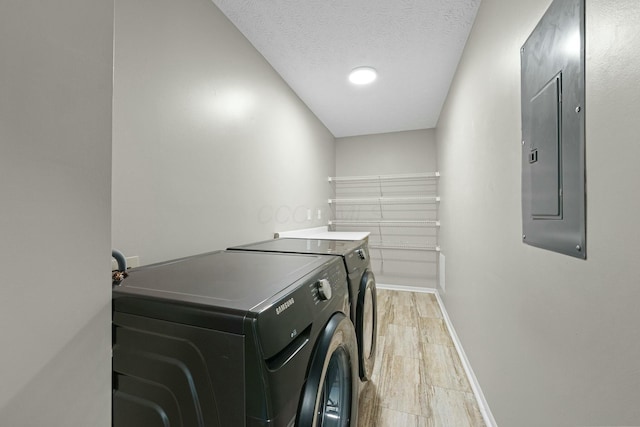 laundry room featuring baseboards, electric panel, laundry area, independent washer and dryer, and a textured ceiling