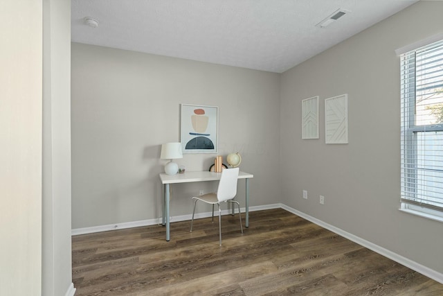 office featuring a textured ceiling, wood finished floors, visible vents, and baseboards