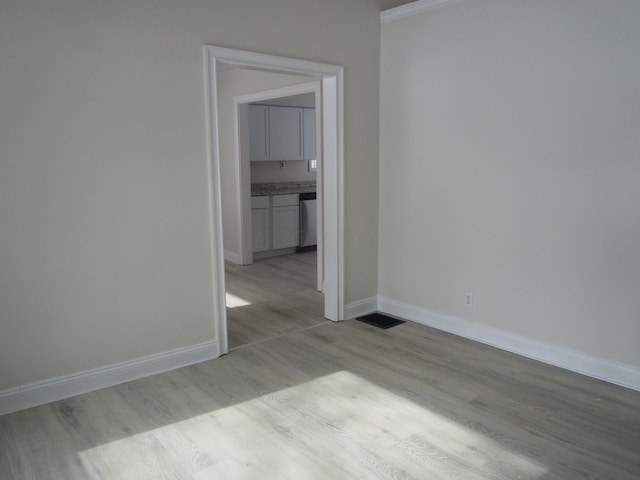 spare room with light wood-style floors and baseboards