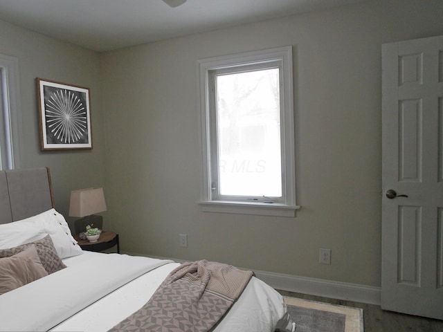 bedroom featuring wood finished floors and baseboards