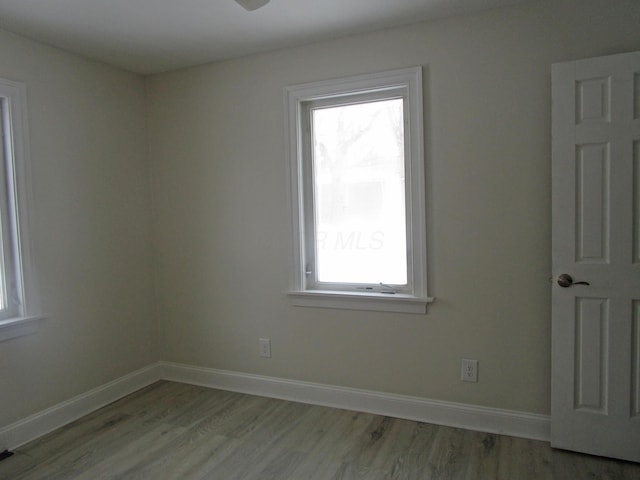 empty room with light wood finished floors and baseboards