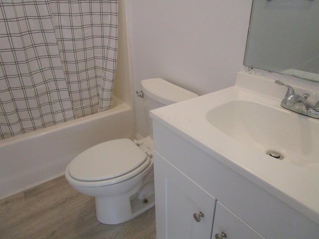 full bath with toilet, wood finished floors, vanity, and shower / bath combination with curtain