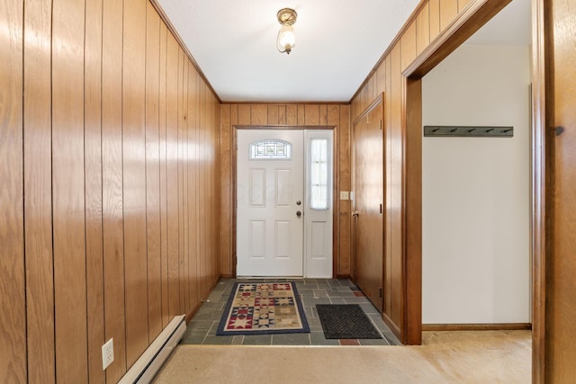 entryway with a baseboard heating unit, baseboards, and wood walls