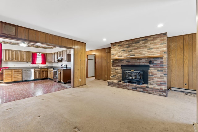 kitchen featuring stainless steel appliances, carpet, and wood walls