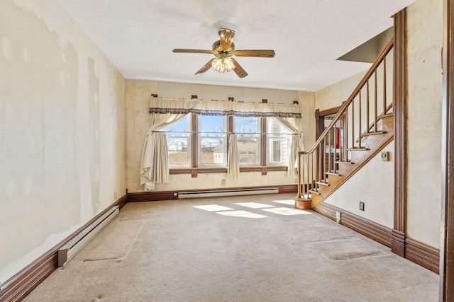 carpeted empty room featuring a baseboard heating unit, ceiling fan, stairway, baseboard heating, and a textured ceiling