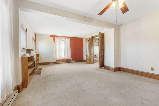 unfurnished living room with a baseboard heating unit, baseboards, carpet floors, baseboard heating, and a ceiling fan