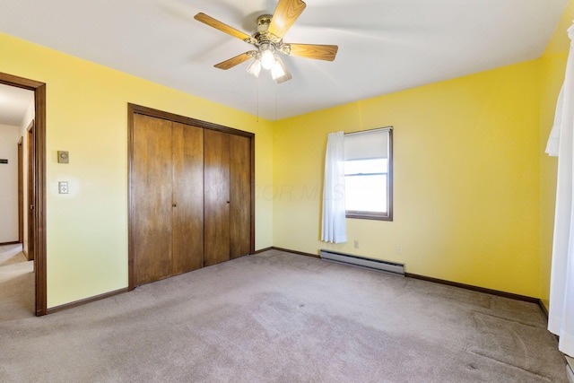 unfurnished bedroom featuring carpet flooring, a closet, and baseboard heating