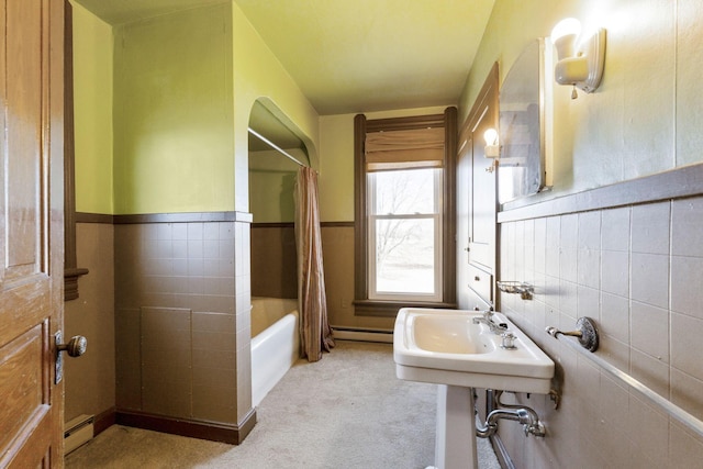 full bathroom featuring tile walls, shower / bath combo with shower curtain, and a baseboard radiator