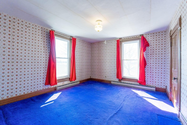 empty room with a wealth of natural light, baseboard heating, and wallpapered walls