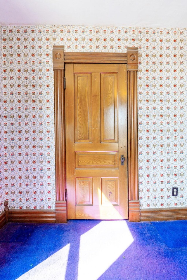 room details featuring wallpapered walls and baseboards