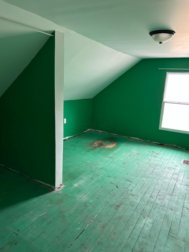 additional living space featuring hardwood / wood-style floors and vaulted ceiling