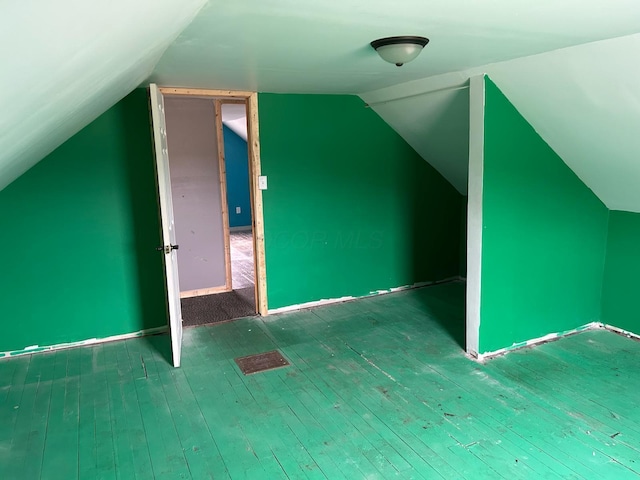 additional living space with wood-type flooring and lofted ceiling