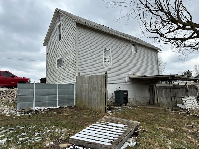 back of house with fence and central AC