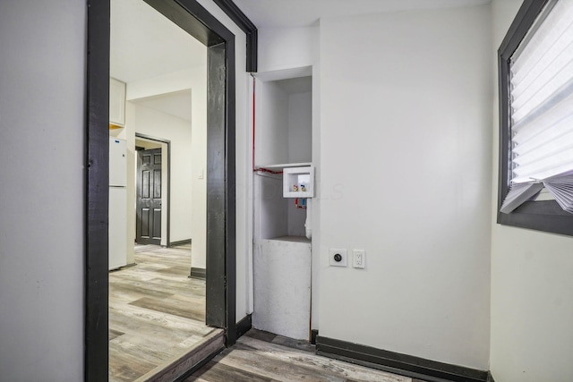 hall featuring baseboards and wood finished floors