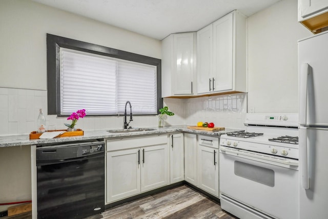 kitchen featuring decorative backsplash, wood finished floors, white cabinets, white appliances, and a sink