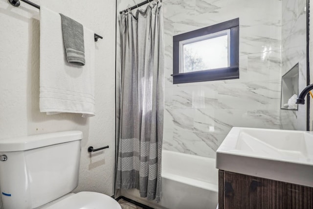 bathroom with vanity, toilet, shower / tub combo, and a textured wall