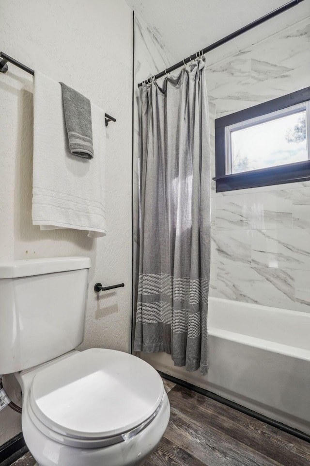 bathroom with toilet, shower / tub combo with curtain, and wood finished floors