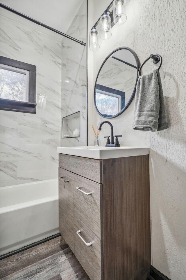 full bath with wood finished floors, vanity, and a textured wall