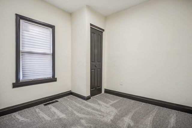 spare room featuring visible vents, baseboards, and carpet floors