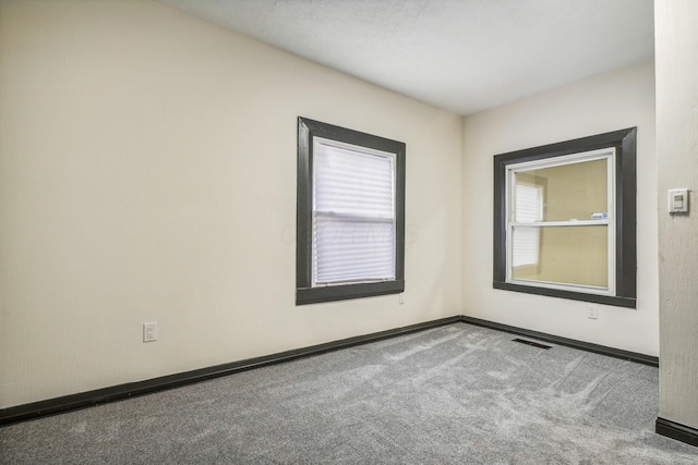 spare room with carpet and baseboards