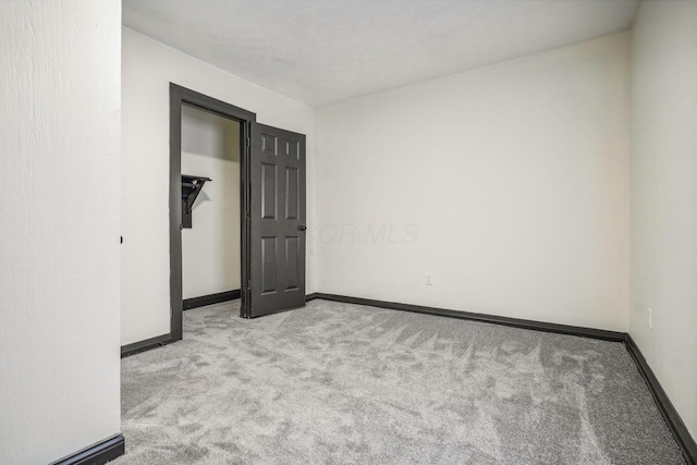 unfurnished bedroom with baseboards and carpet floors