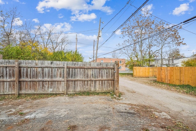 exterior space with dirt driveway and a gated entry