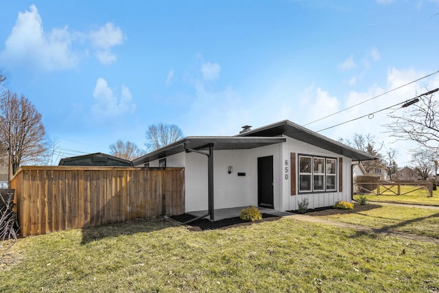 view of front of house with a front lawn and fence