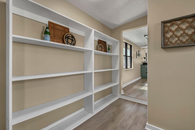 hallway with baseboards and wood finished floors