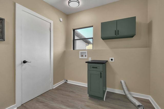 clothes washing area featuring baseboards, washer hookup, wood finished floors, cabinet space, and hookup for an electric dryer