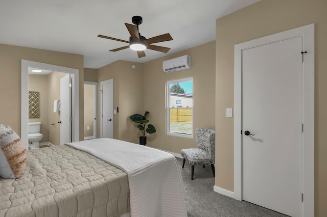 bedroom with baseboards, carpet floors, ensuite bathroom, a wall mounted AC, and a ceiling fan