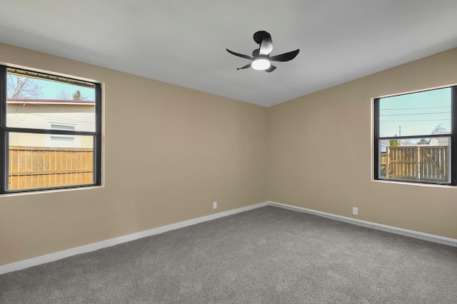 empty room featuring baseboards, carpet floors, and a ceiling fan