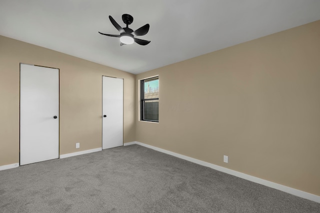 unfurnished bedroom featuring ceiling fan, lofted ceiling, baseboards, and carpet floors