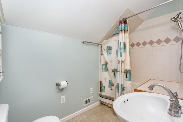 full bath with visible vents, baseboards, toilet, tiled shower, and a sink