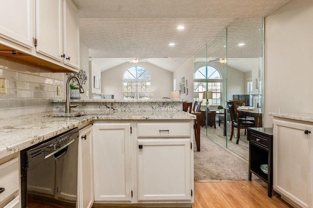 kitchen with dishwasher, a peninsula, white cabinetry, a ceiling fan, and a sink