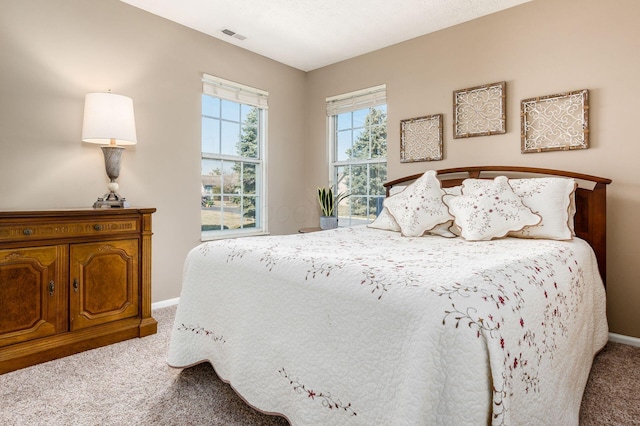 carpeted bedroom with visible vents and baseboards