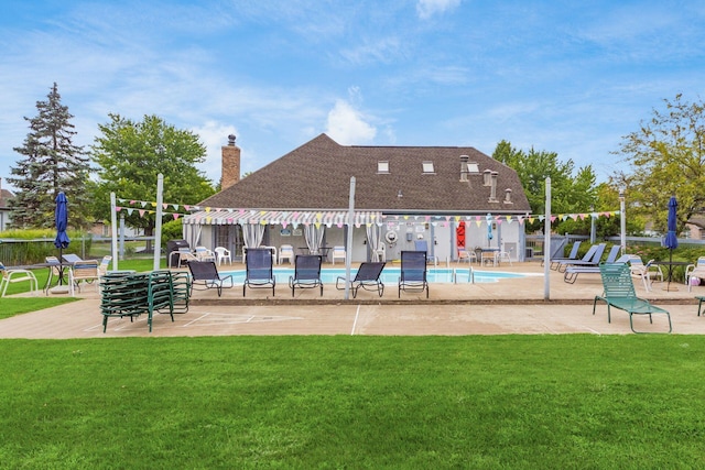 pool with a patio area and a lawn