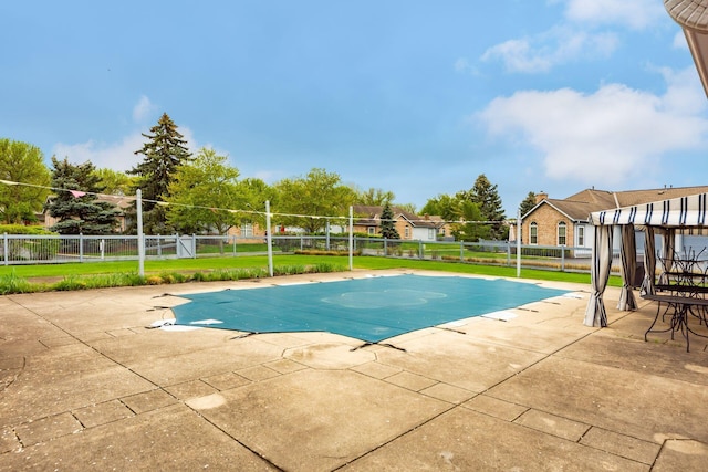 view of swimming pool with a patio, fence, and volleyball court