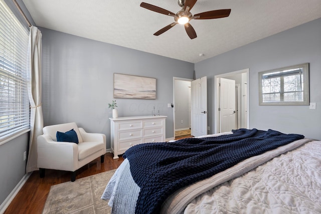 bedroom with a textured ceiling, a ceiling fan, baseboards, and wood finished floors