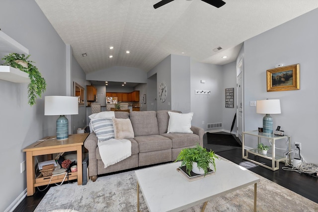 living room featuring a ceiling fan, visible vents, baseboards, lofted ceiling, and dark wood-type flooring