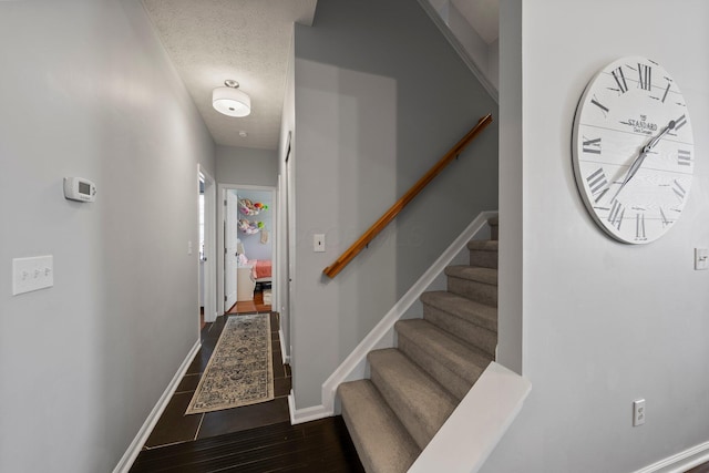 interior space featuring wood finished floors, baseboards, and a textured ceiling