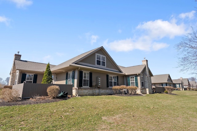 view of front facade featuring stone siding, a chimney, and a front lawn