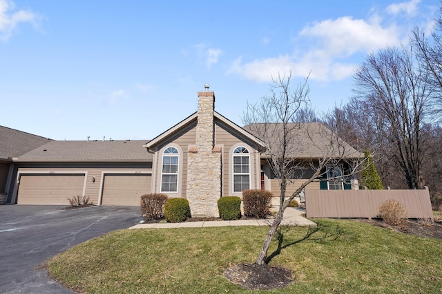 ranch-style home featuring a front lawn, aphalt driveway, fence, a garage, and a chimney