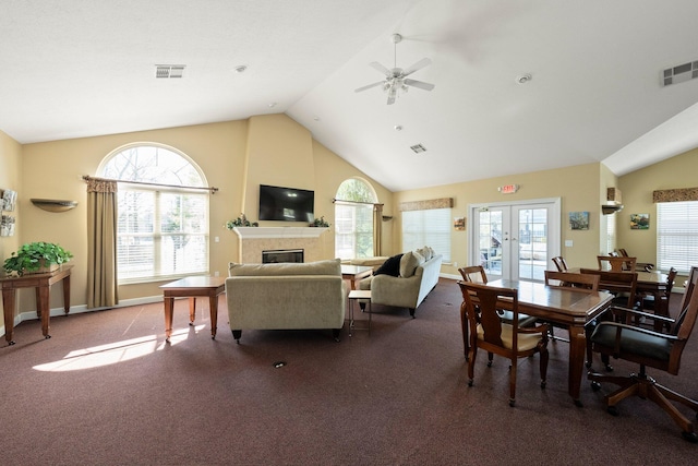 dining area featuring a tiled fireplace, visible vents, and dark carpet