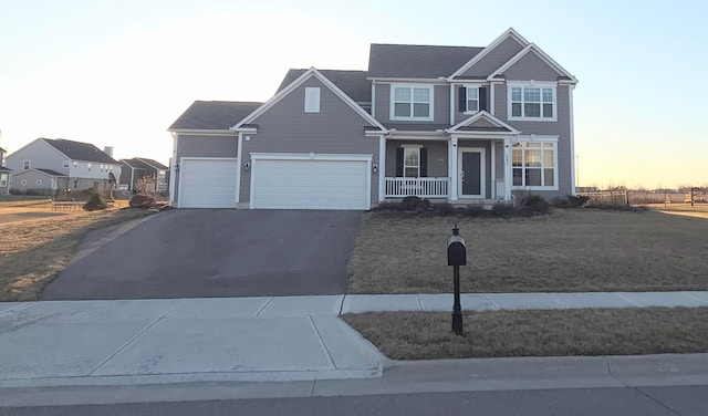 view of front of property with aphalt driveway, covered porch, an attached garage, and a yard