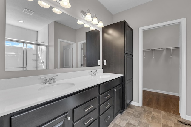 full bath with visible vents, a sink, and double vanity