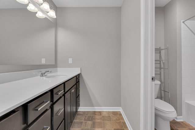 bathroom with baseboards, toilet, vanity, and an inviting chandelier