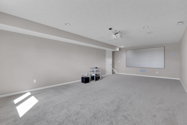 cinema featuring baseboards, visible vents, carpet floors, and a textured ceiling